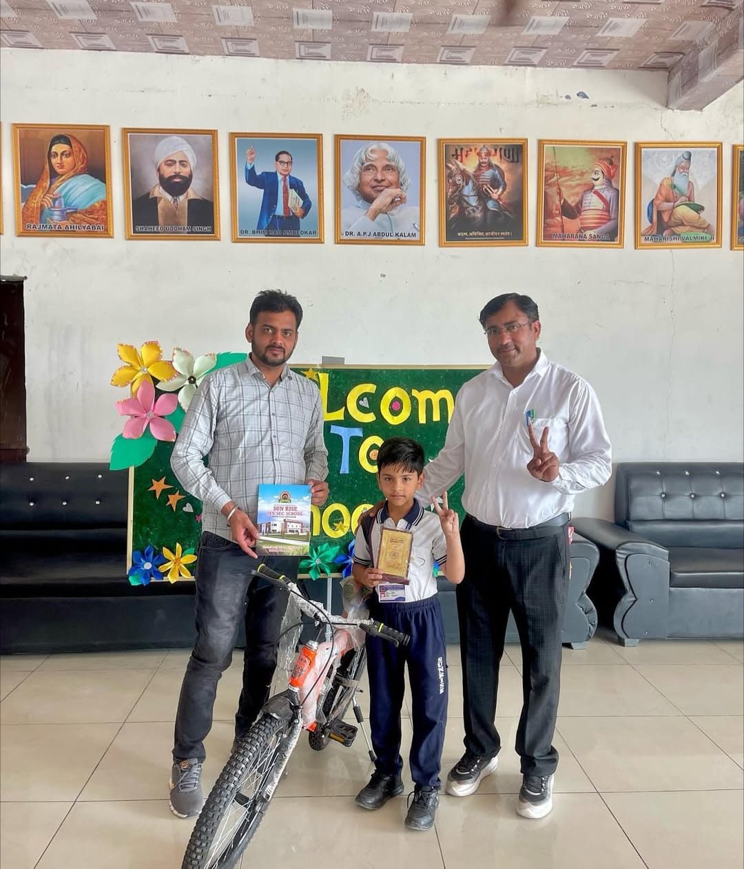 Student receiving a bicycle and certificate from teachers