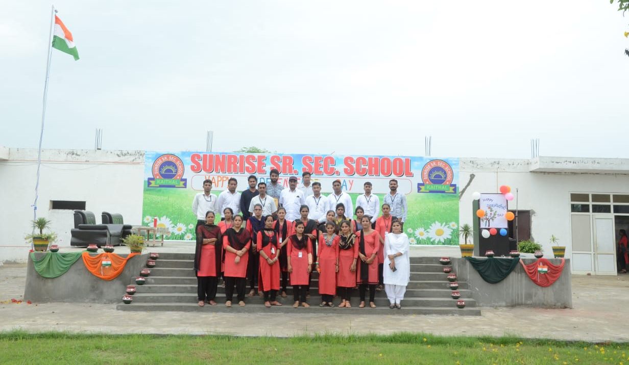 Students and staff in front of the school
