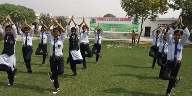 Students doing yoga on the school playground